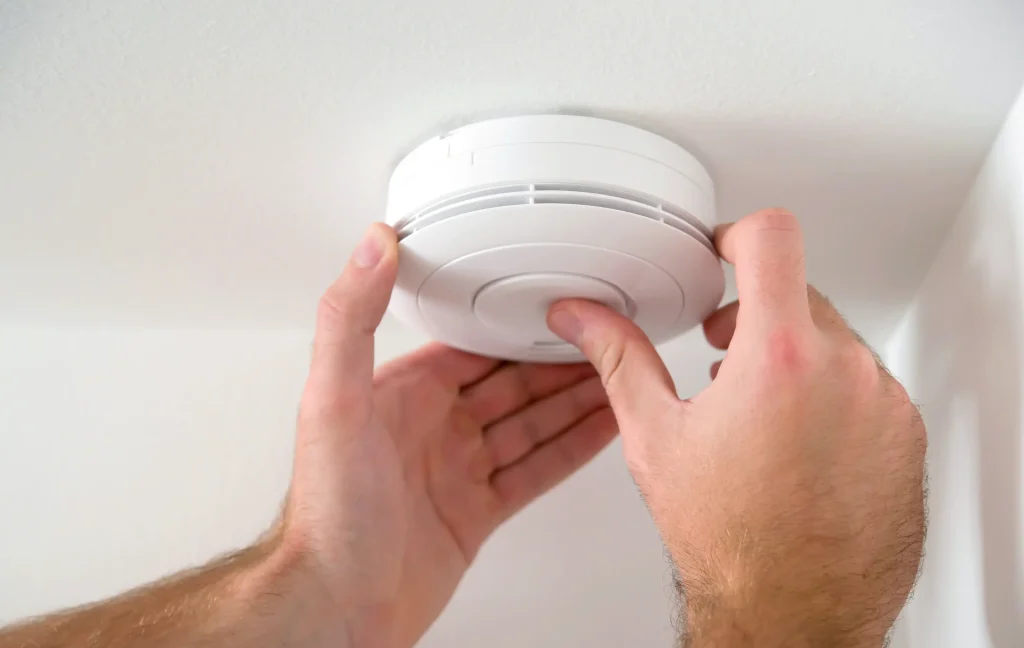 licensed electrician installing a new smoke alarm in Melbourne
